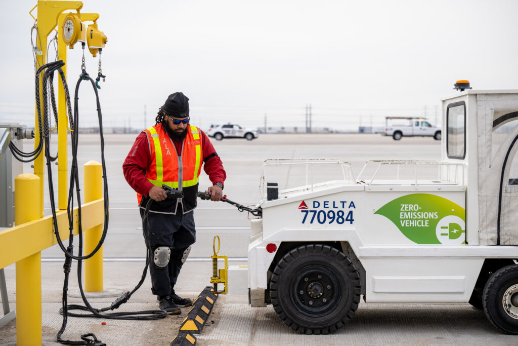 Aircraft Load Agent Thomas Tuikolovatu plugs in an electric bag tractor for charging at Salt Lake City International Airport (SLC).